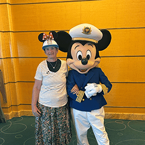 Margaret meeting Mickey Mouse during an NDIS respite trip.